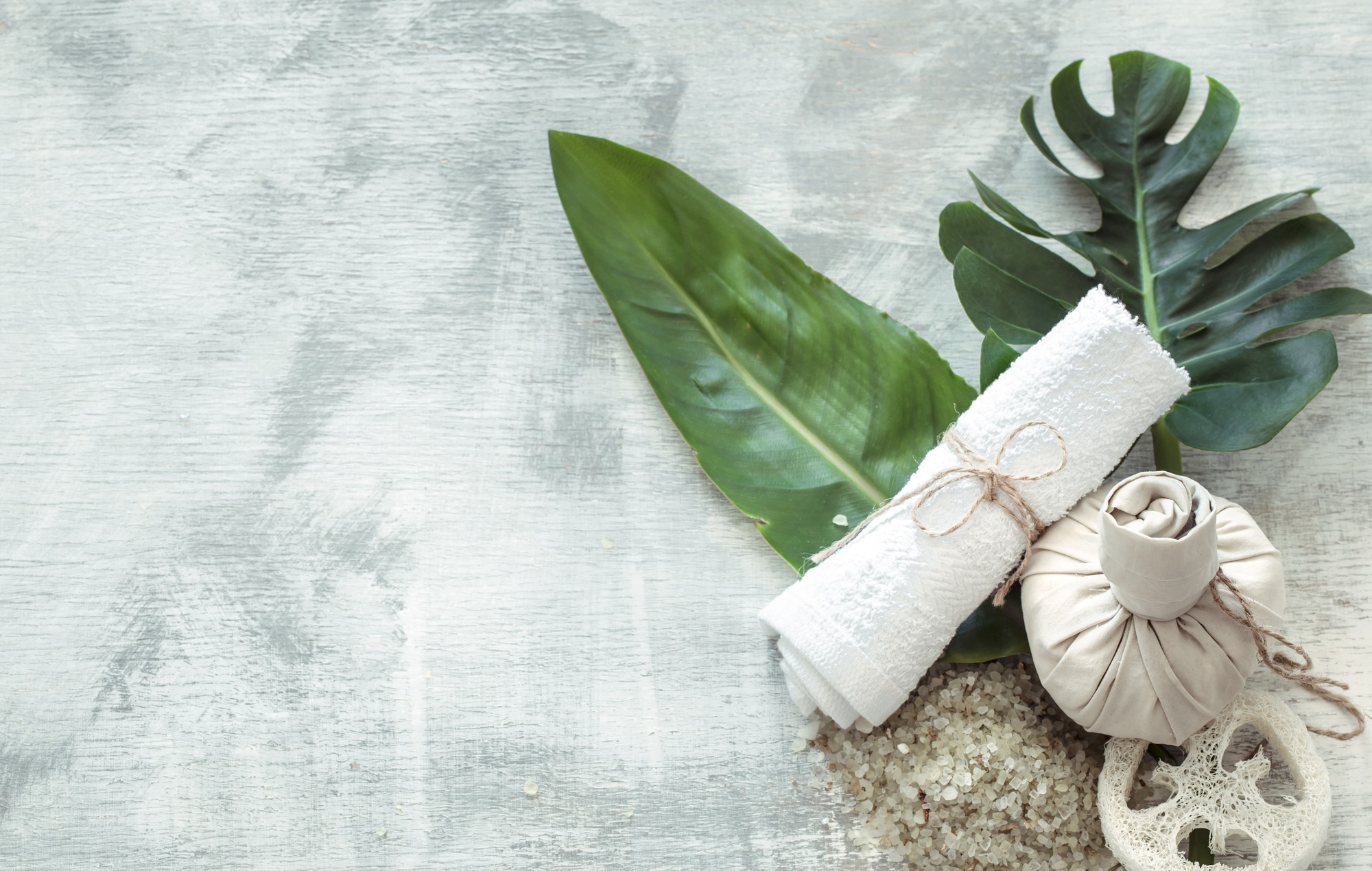 spa-composition-with-body-care-items-light-wall